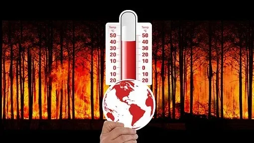 Ein Thermometer und eine Erdkugel, im Hintergrund brennender Wald